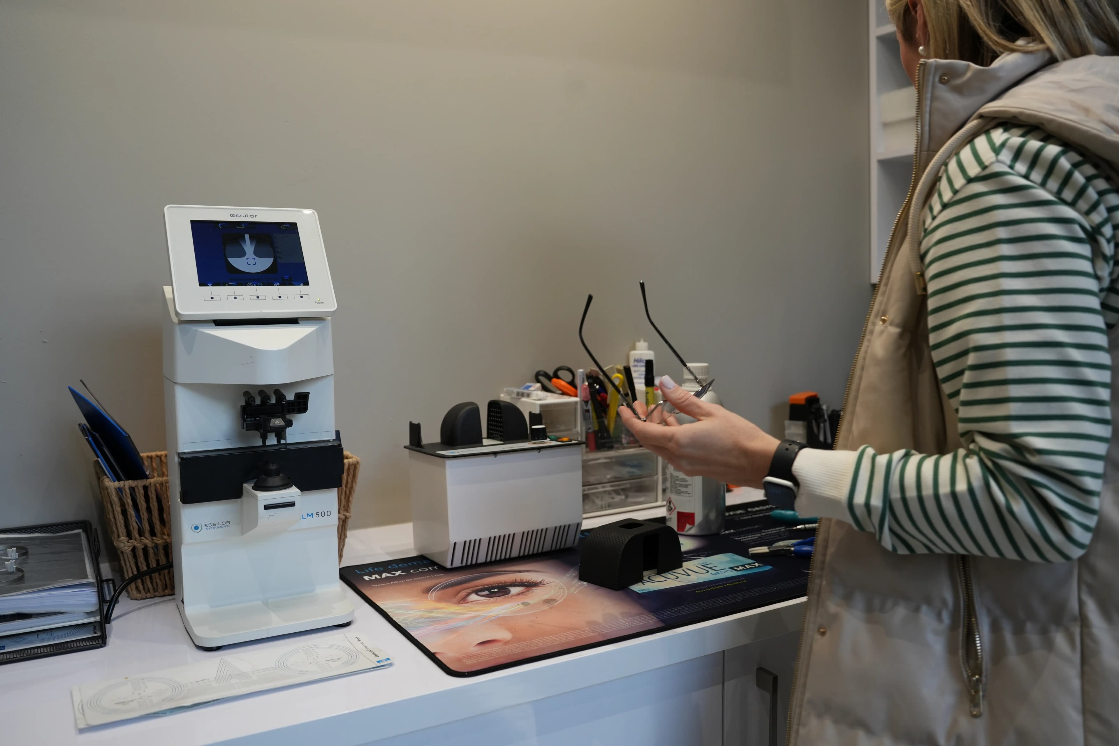 Lens cutting and fitting machine shaping a new lens for designer frames at Reza Ferreira Boutique Optometrists