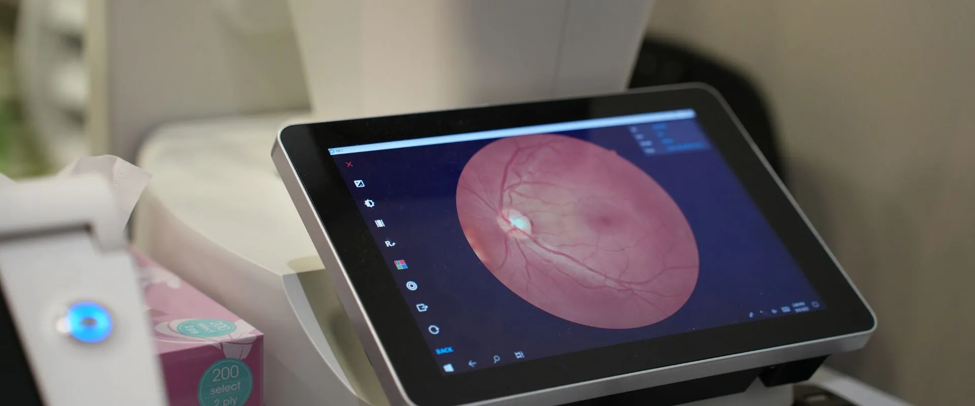 Retinal health assessment showing a detailed retinal image with the optic disc and blood vessels on a digital imaging screen at Reza Ferreira Boutique Optometrists
