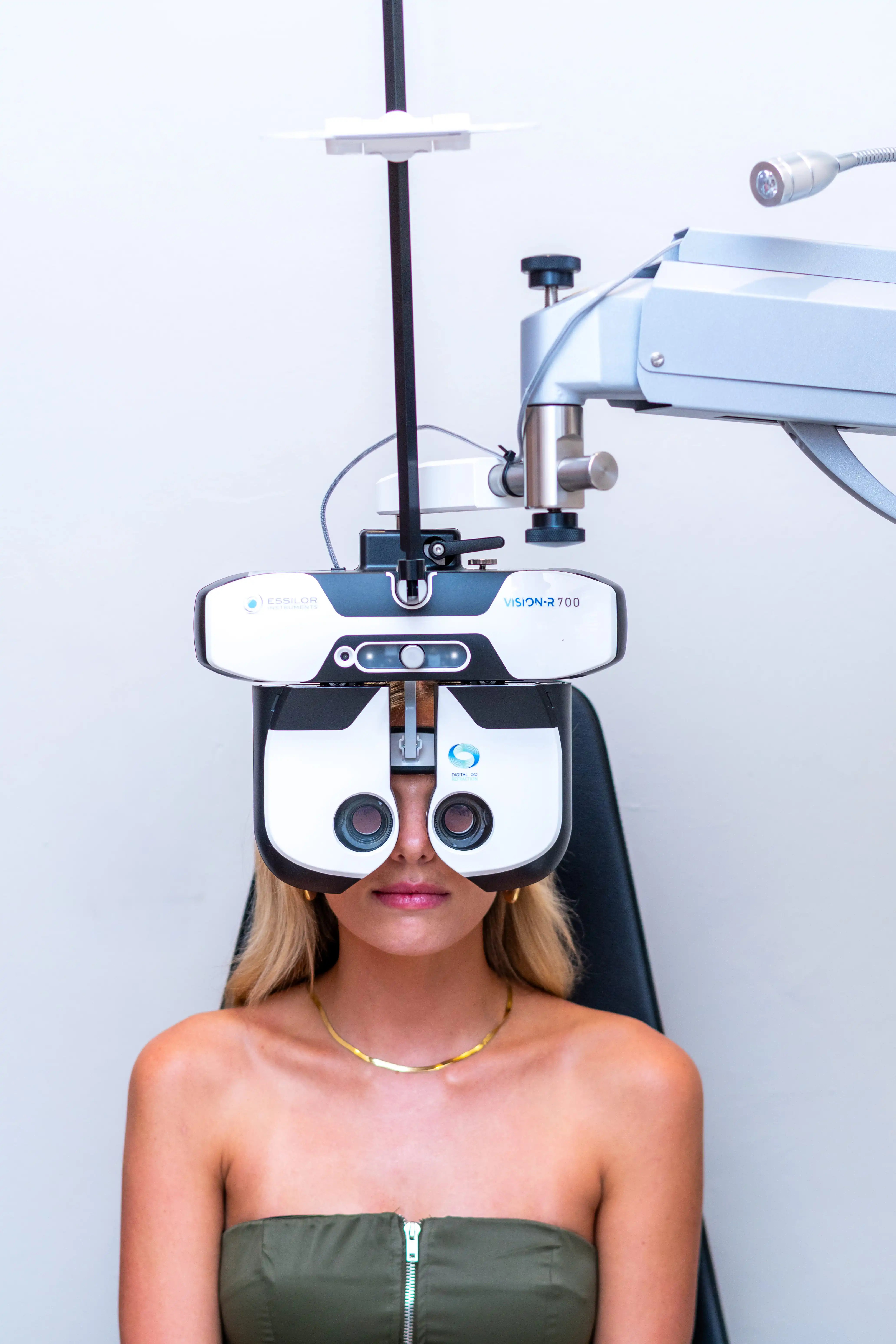 Patient undergoing a precision eye test with the Essilor Vision-R 700 digital refractor at the Reza Ferreira Paarl practice