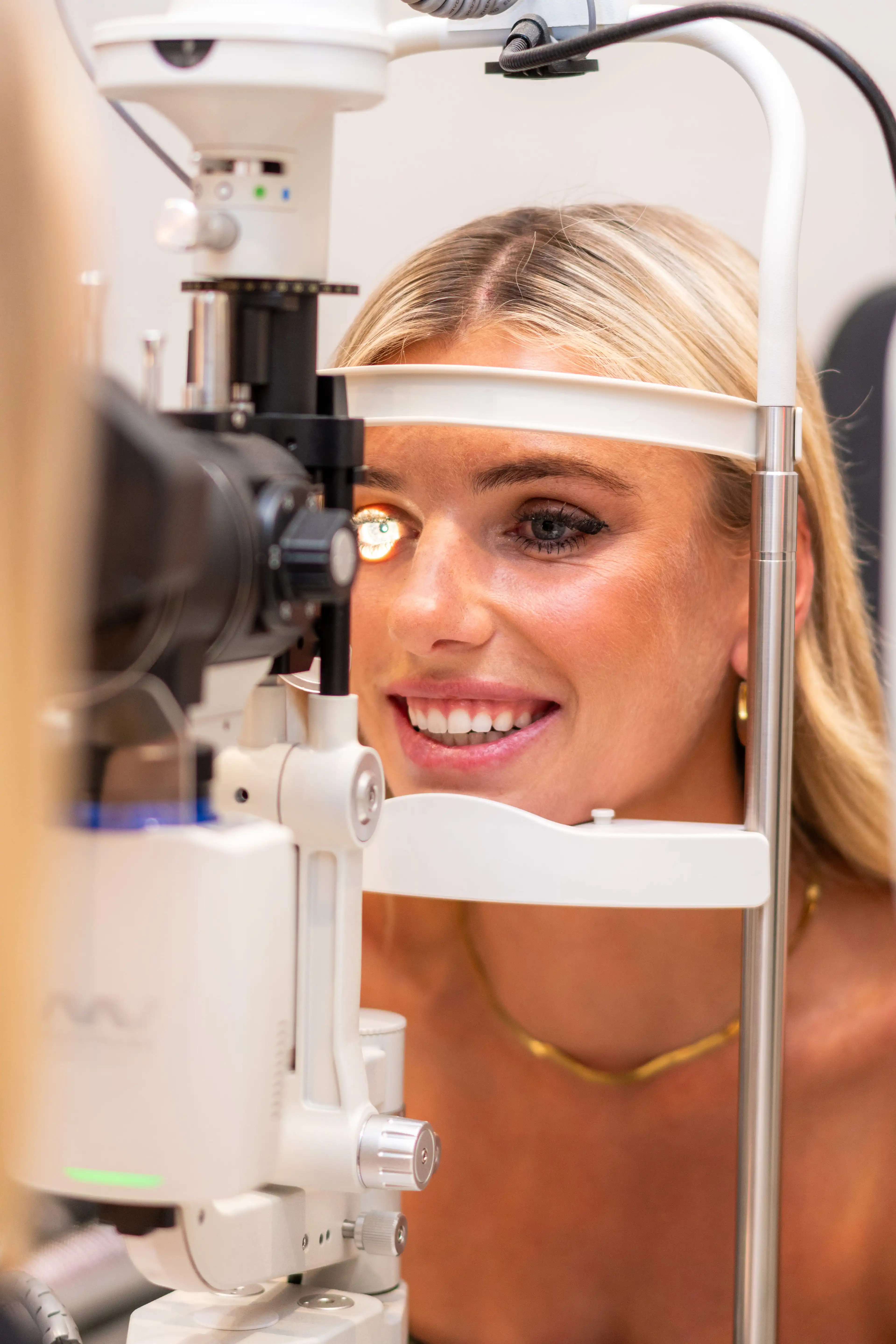 Smiling patient during a slit lamp eye examination at Reza Ferreira Boutique Optometrists